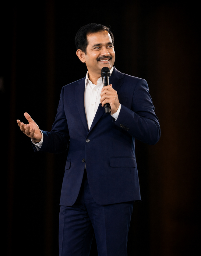 Suresh Manickam speaking on stage